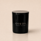 Flamma Hestia OIKOS luxury candle in a reusable black glass vessel, gardenia and vanilla fragrance